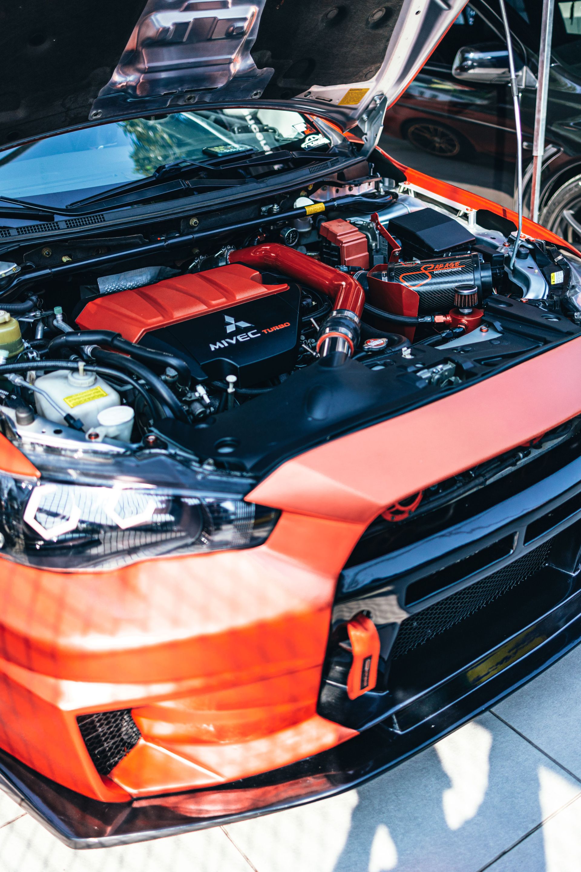 Detailed close-up of a high-performance car engine with red accents under the hood.