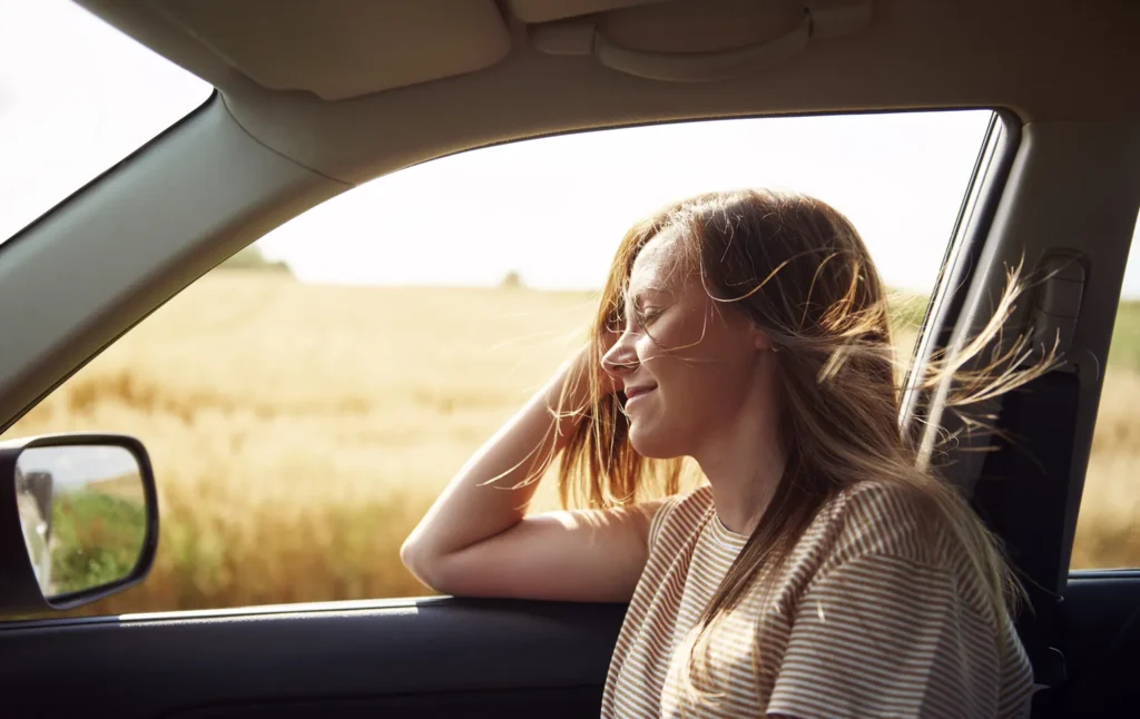 Woman looking outside a moving car very relaxed
